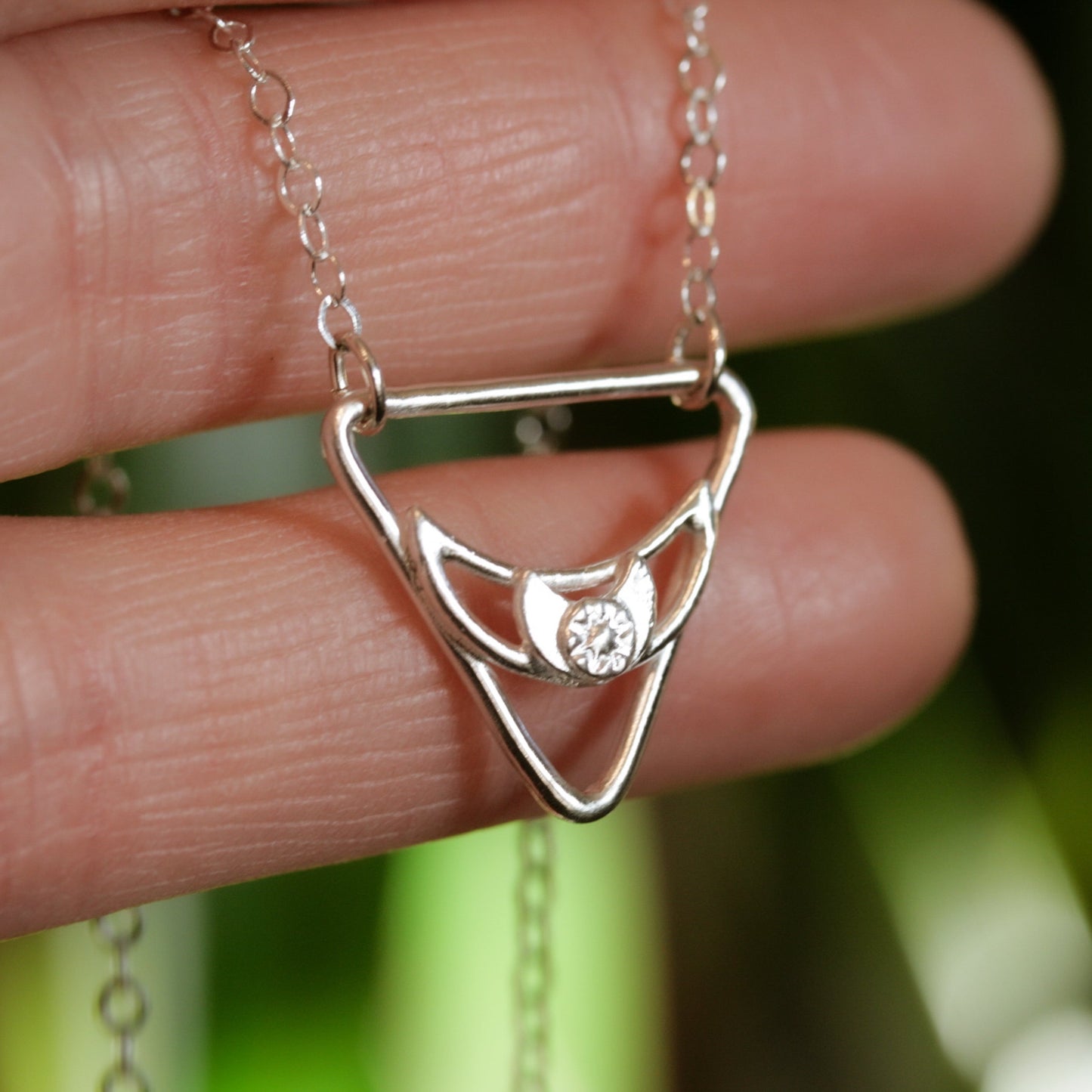 silver triangle pendant with moon and star